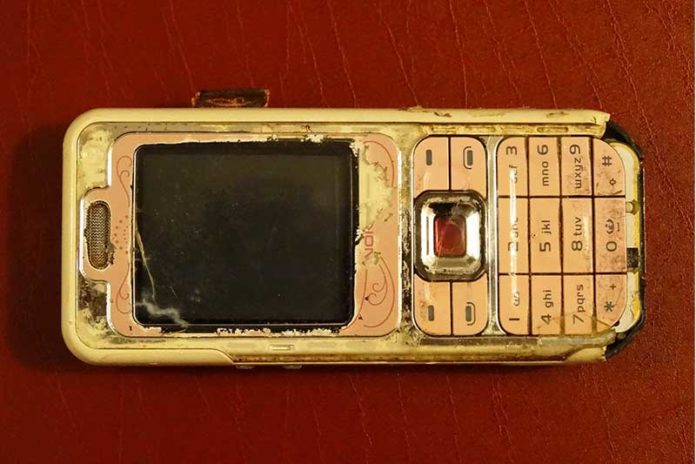 Telefon i vjetër nokia mbi tavolinë me mbulesë të kuqe
