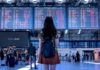 Google Flights do të Parashikojë Vonesat e Fluturimeve Nje vajze qe po sheh orarin e udhetimit ne aeroport