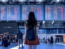 Google Flights do të Parashikojë Vonesat e Fluturimeve Nje vajze qe po sheh orarin e udhetimit ne aeroport