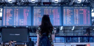 Google Flights do të Parashikojë Vonesat e Fluturimeve Nje vajze qe po sheh orarin e udhetimit ne aeroport
