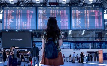 Google Flights do të Parashikojë Vonesat e Fluturimeve Nje vajze qe po sheh orarin e udhetimit ne aeroport