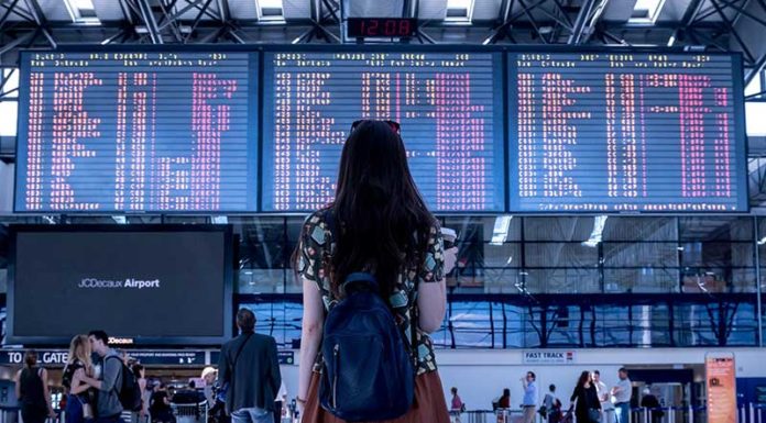 Google Flights do të Parashikojë Vonesat e Fluturimeve Nje vajze qe po sheh orarin e udhetimit ne aeroport
