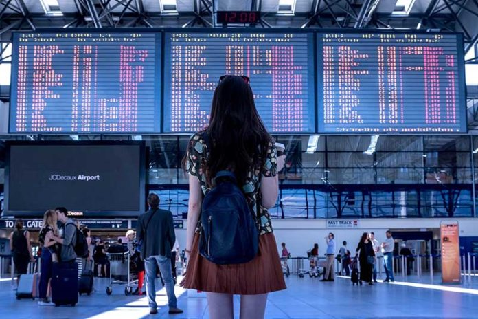 Nje vajze qe po sheh orarin e udhetimit ne aeroport