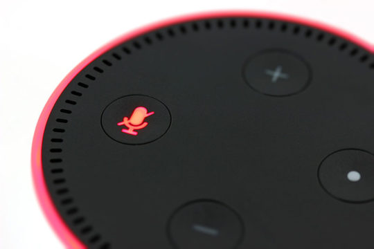 Nje aparat amazon echo dot me ngjyre te zeze dhe me shenjen e mikrofonit te kuqe