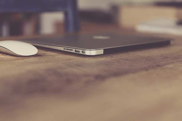 Lajme-Tech_apple_macbook-air_mouse Kompjuter macbook air ngjyre gri dhe nje mouse i bardhe mbi nje tavoline druri