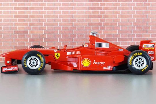 Makine Ferrari e kuqe para nje muri