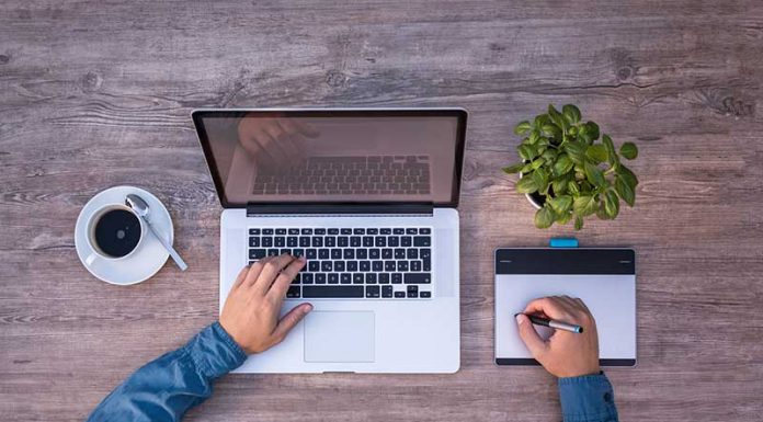 Apple ble një kompani të re çdo 2-3 javë Një djale me kompjuter mac ne tavoline dhe kafe duke shkruar ne nje magic trackpad