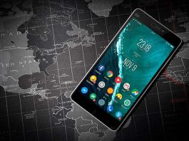 Telefon i zi me sistem operativ Android mbi hartën e botes ngjyre gri