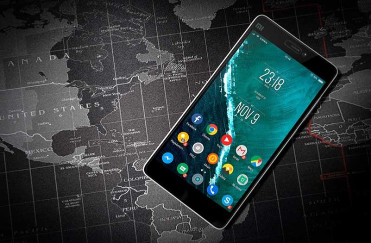 Telefon i zi me sistem operativ Android mbi hartën e botes ngjyre gri