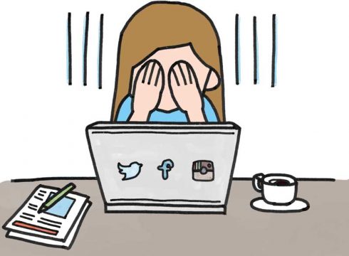 Vajze qe mbulon syte para kompjuterit me etiketat e instagram, facebook dhe twitter