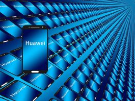 Telefon Huawei në plan te pare me ekran ngjyre blu dhe qindra tablet e telefona ne sfond