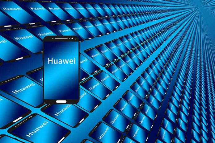 Telefon Huawei në plan te pare me ekran ngjyre blu dhe qindra tablet e telefona ne sfond