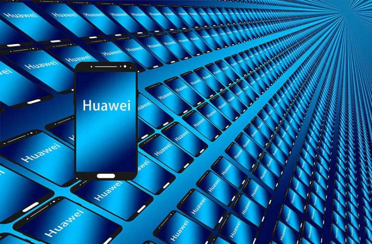 Telefon Huawei në plan te pare me ekran ngjyre blu dhe qindra tablet e telefona ne sfond
